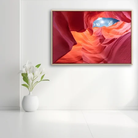 Canyon interior with glowing red sandstone and blue sky opening