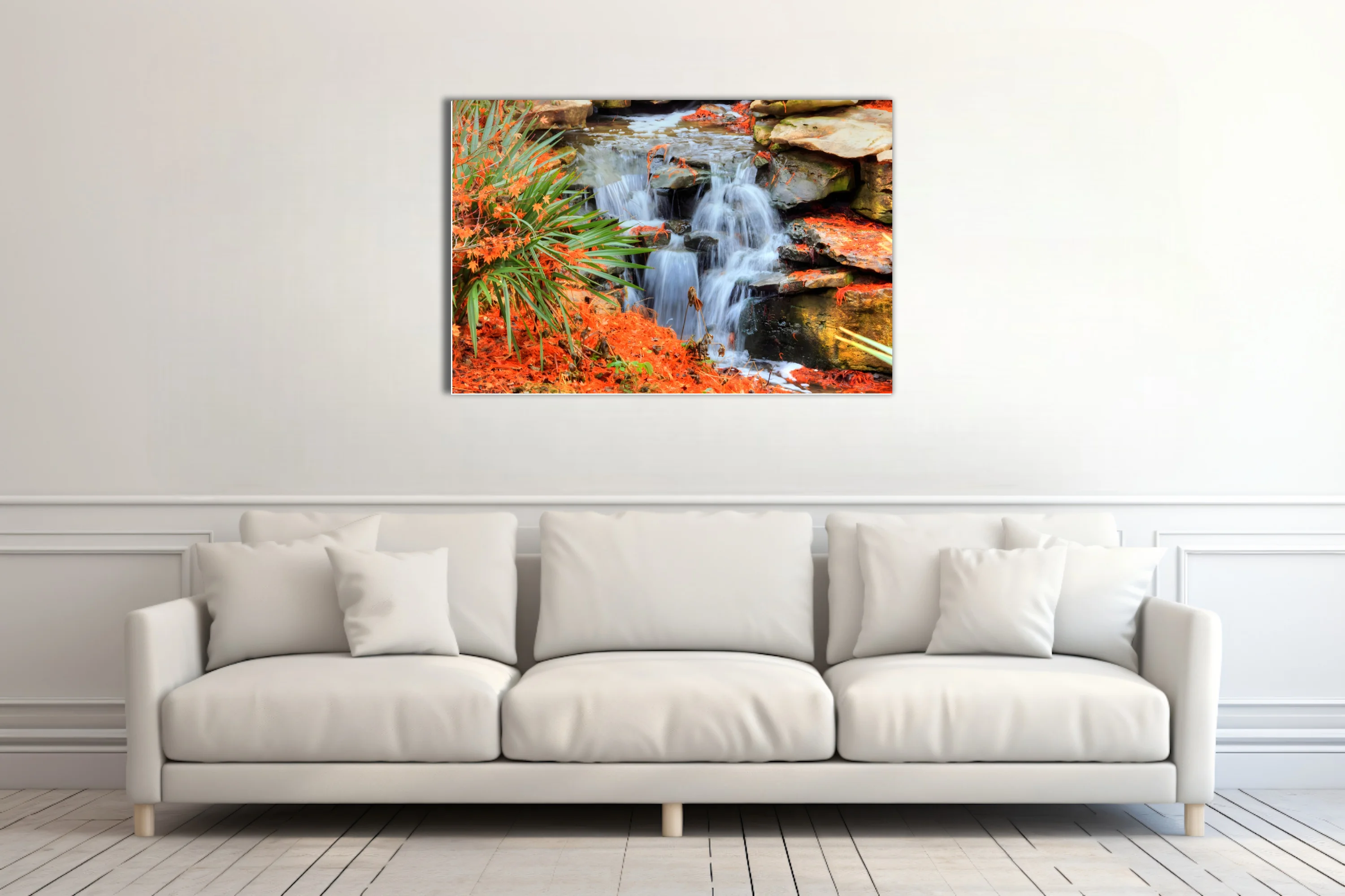 Cascading waterfall over mossy rocks with vivid orange foliage and green palms