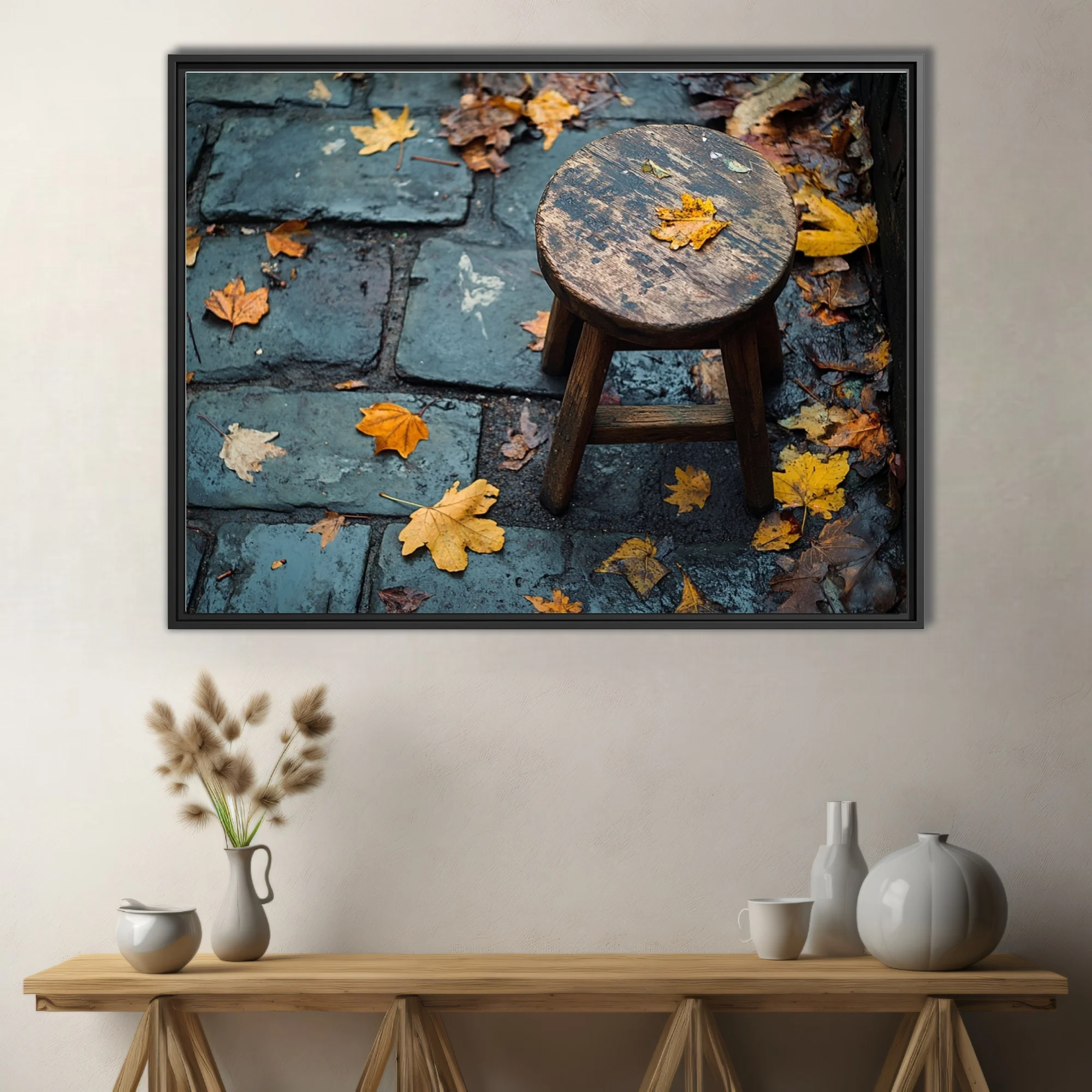 Rustic wooden stool on wet cobblestone with scattered autumn leaves, moody seasonal photo