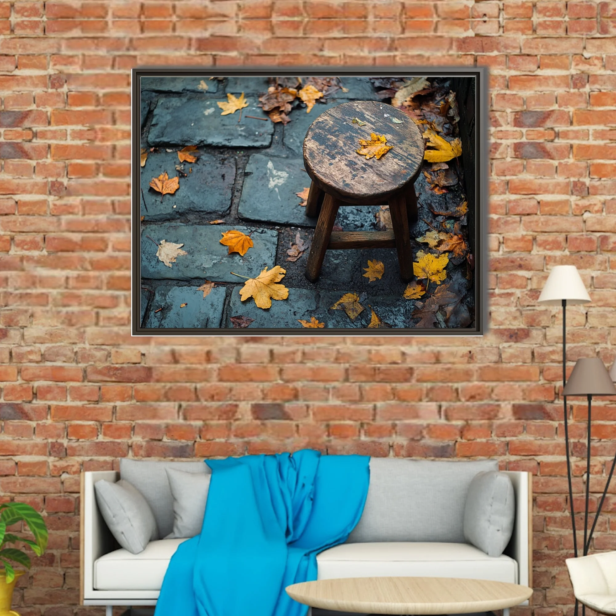 Rustic wooden stool on wet cobblestone with scattered autumn leaves, moody seasonal photo