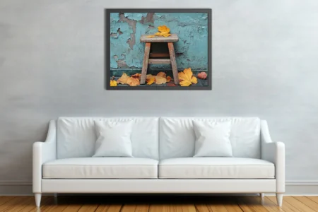 Rustic wooden stool with golden autumn leaves against peeling teal wall