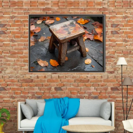 Rustic weathered wooden stool on wet stone surrounded by autumn leaves