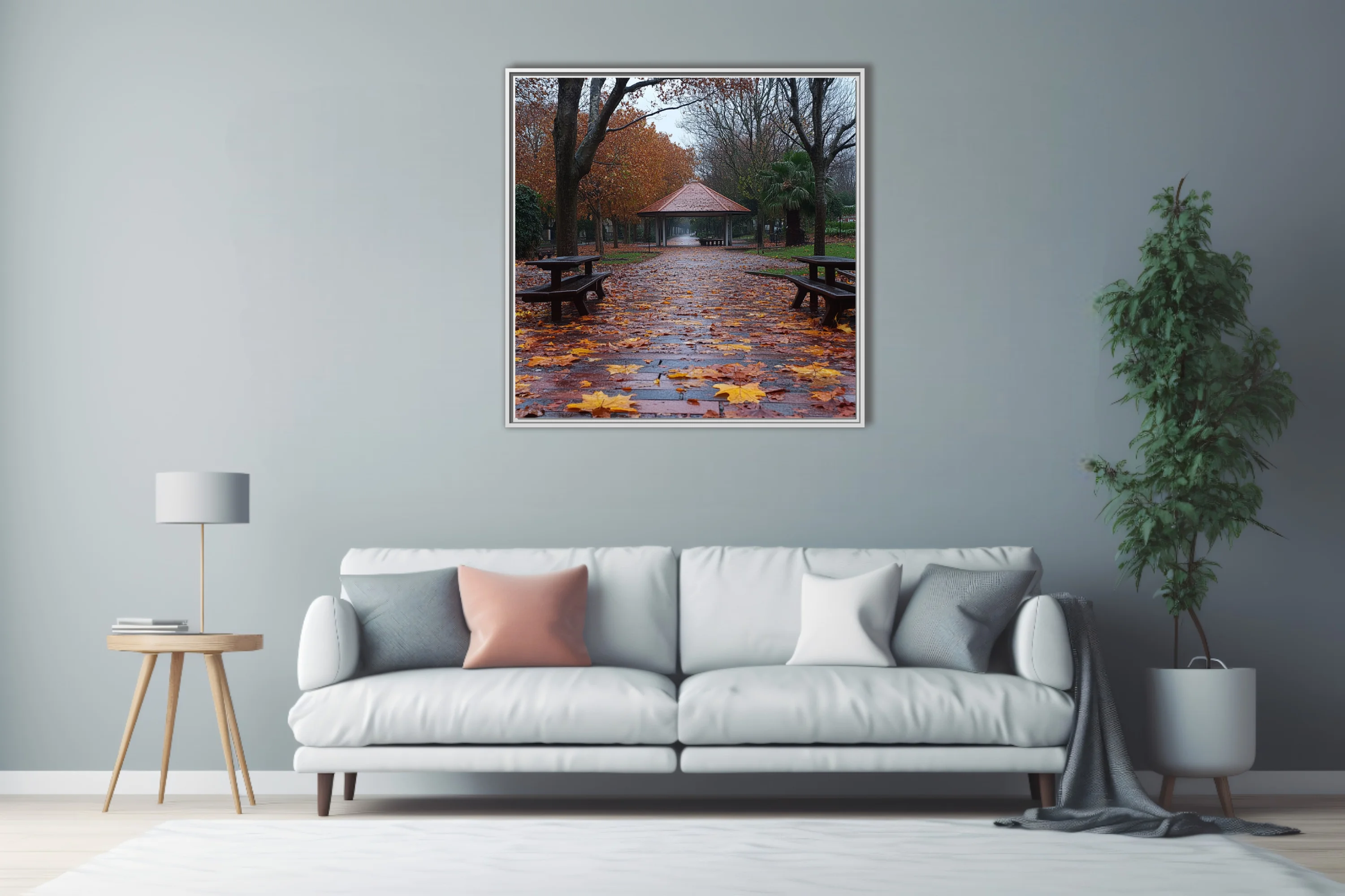 Rainy autumn park path with fallen leaves, picnic tables, and a gazebo in muted amber and grey