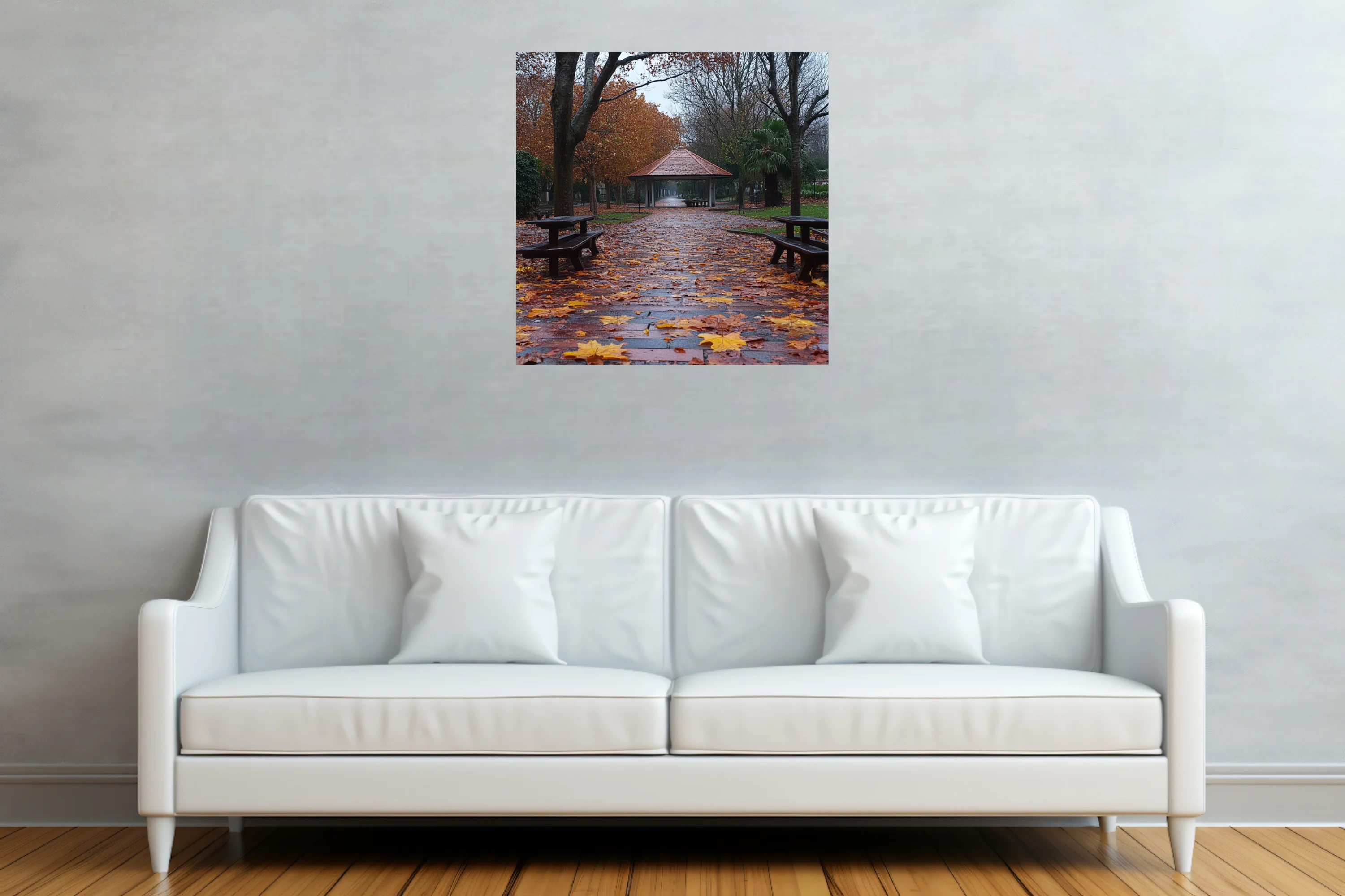 Rainy autumn park path with fallen leaves, picnic tables, and a gazebo in muted amber and grey