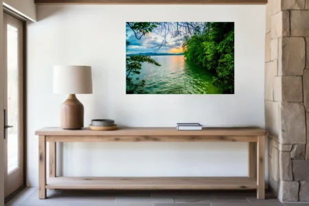 Lush forested lake at golden sunset with misty mountain backdrop and calm water