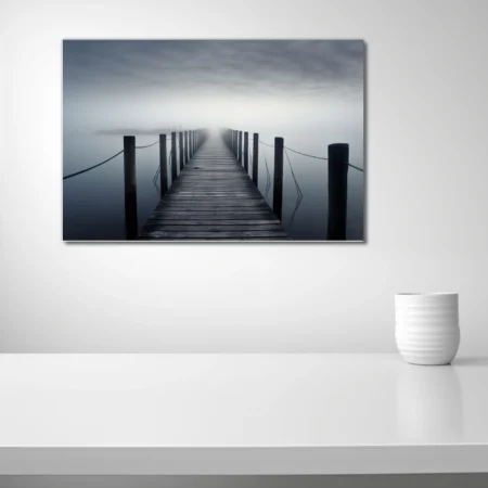 Minimalist foggy pier over still water, monochrome long-exposure photography