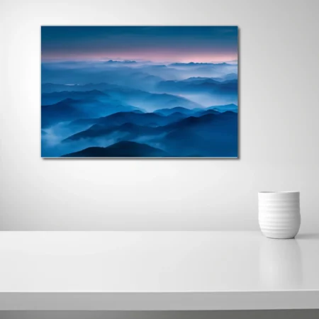 Misty blue mountain ranges at twilight, layered ridgelines fading into pink dusk sky