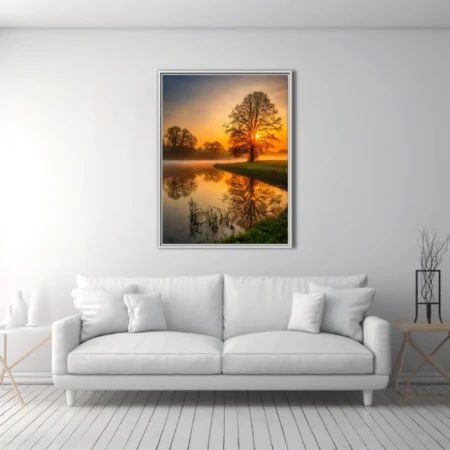 Misty golden sunrise landscape with tree silhouettes reflected in calm river